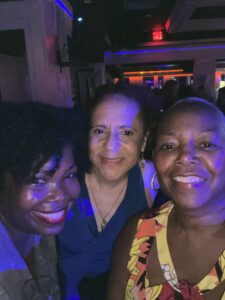 Three African-American women smiling brightly