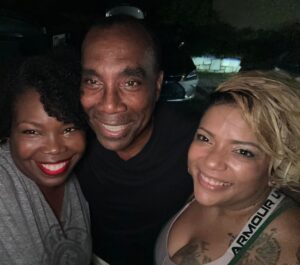 Three African-American women smiling brightly